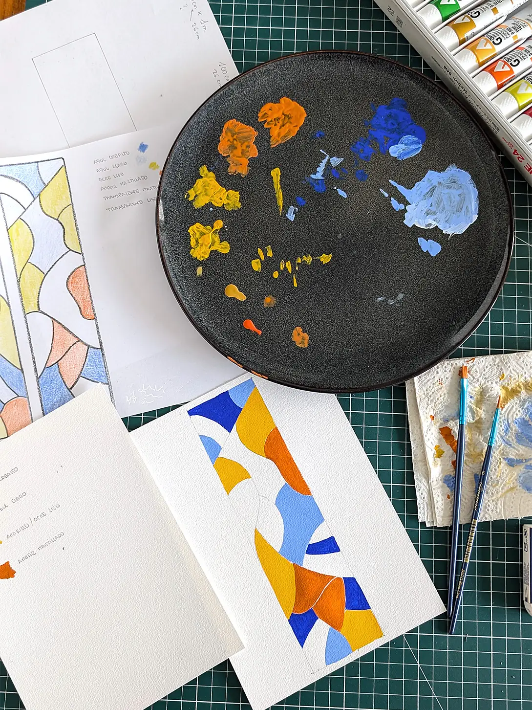 Process work for Fragments du ciel: gouache colour studies, pencil sketches and a palette plate on the studio worktable